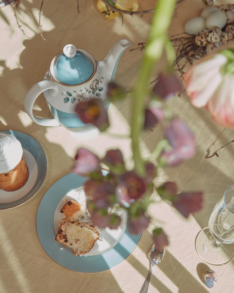 пасхальный стол с голубым чайником и сиреневым цветком