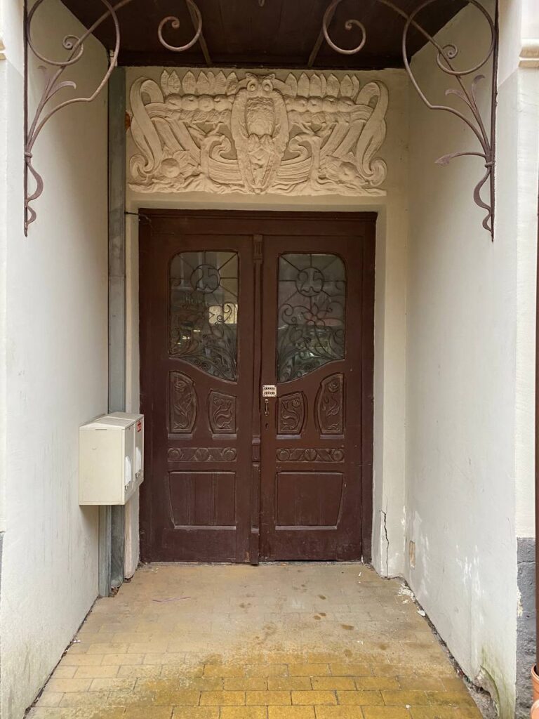 старинная коричневая дверь и белая лепнина