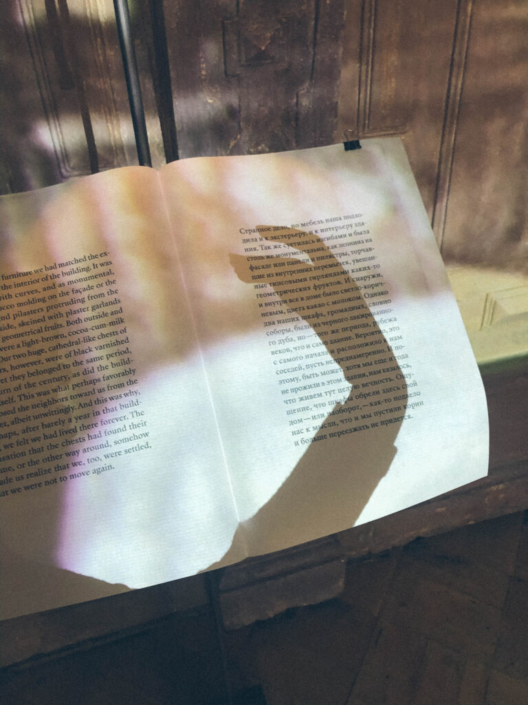 тень руки на фоне открытой книги