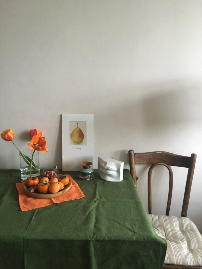 миска с фруктами и зеленая скатерть на столе