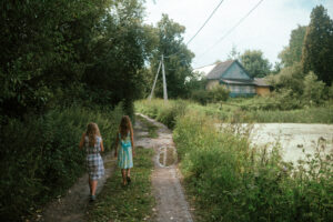 две девочки идут по дачной зеленой дороге