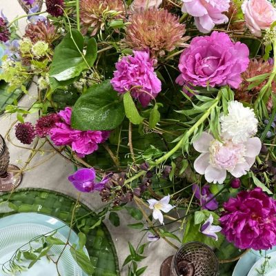 розы лилового цвета и белые пионы в сервировке стола